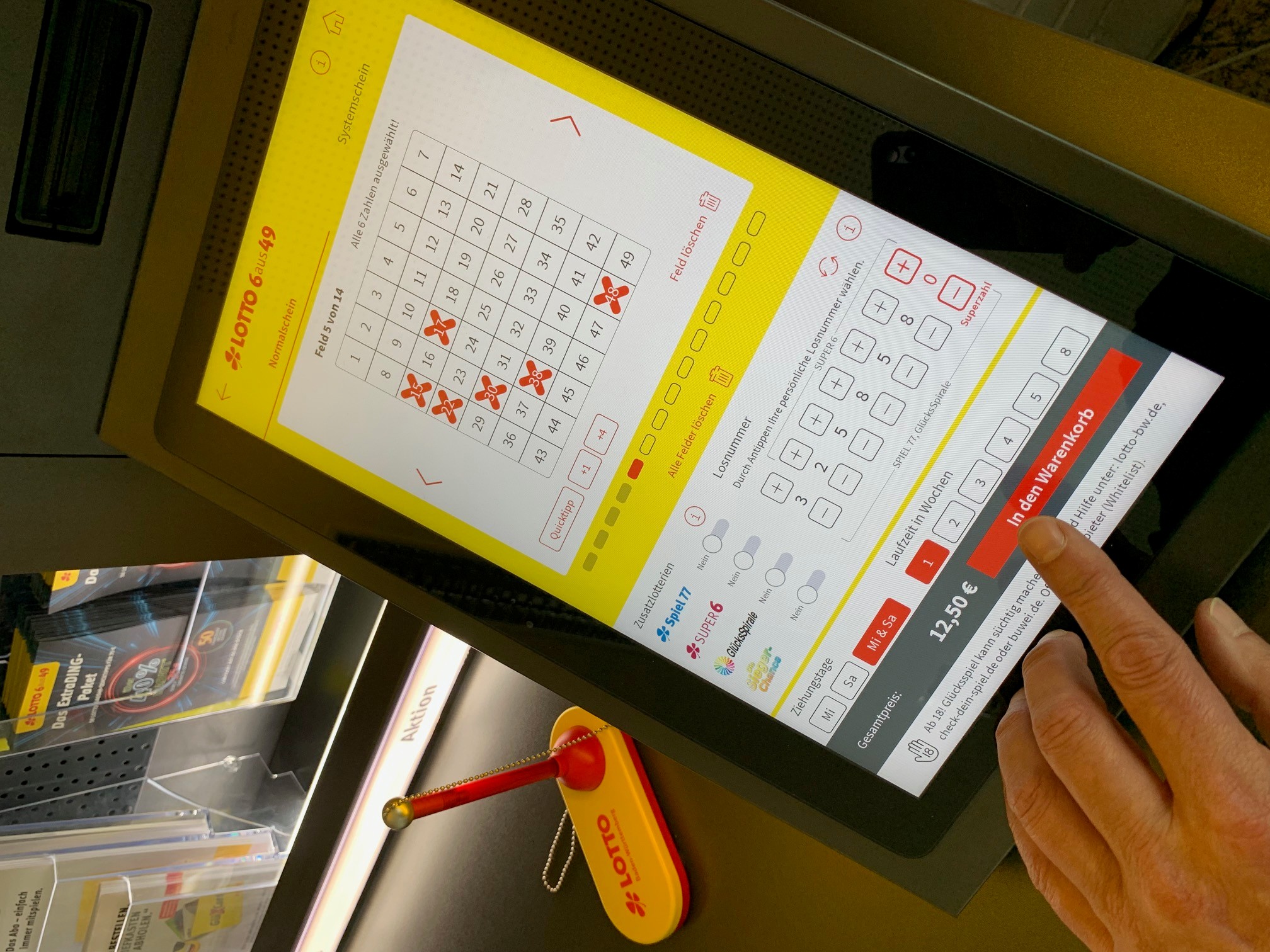 Lotto-Tablet mit ausgefülltem Spielschein und Warenkorb-Auswahl.
