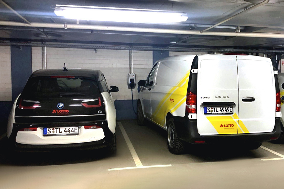 Zwei E-Autos stehen nebeneinander an der Ladestation in der Tiefgarage.