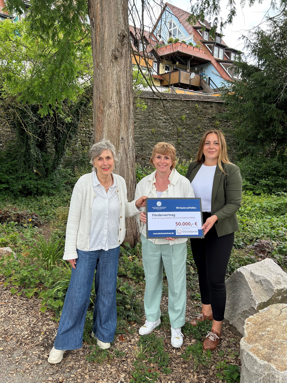 Dr. Anita Auer von der DSD (links) und Regionaldirektorin Marina Roßmann (rechts) überreichen den Förderbescheid an Projektleiterin Dr. Christine Blessing
