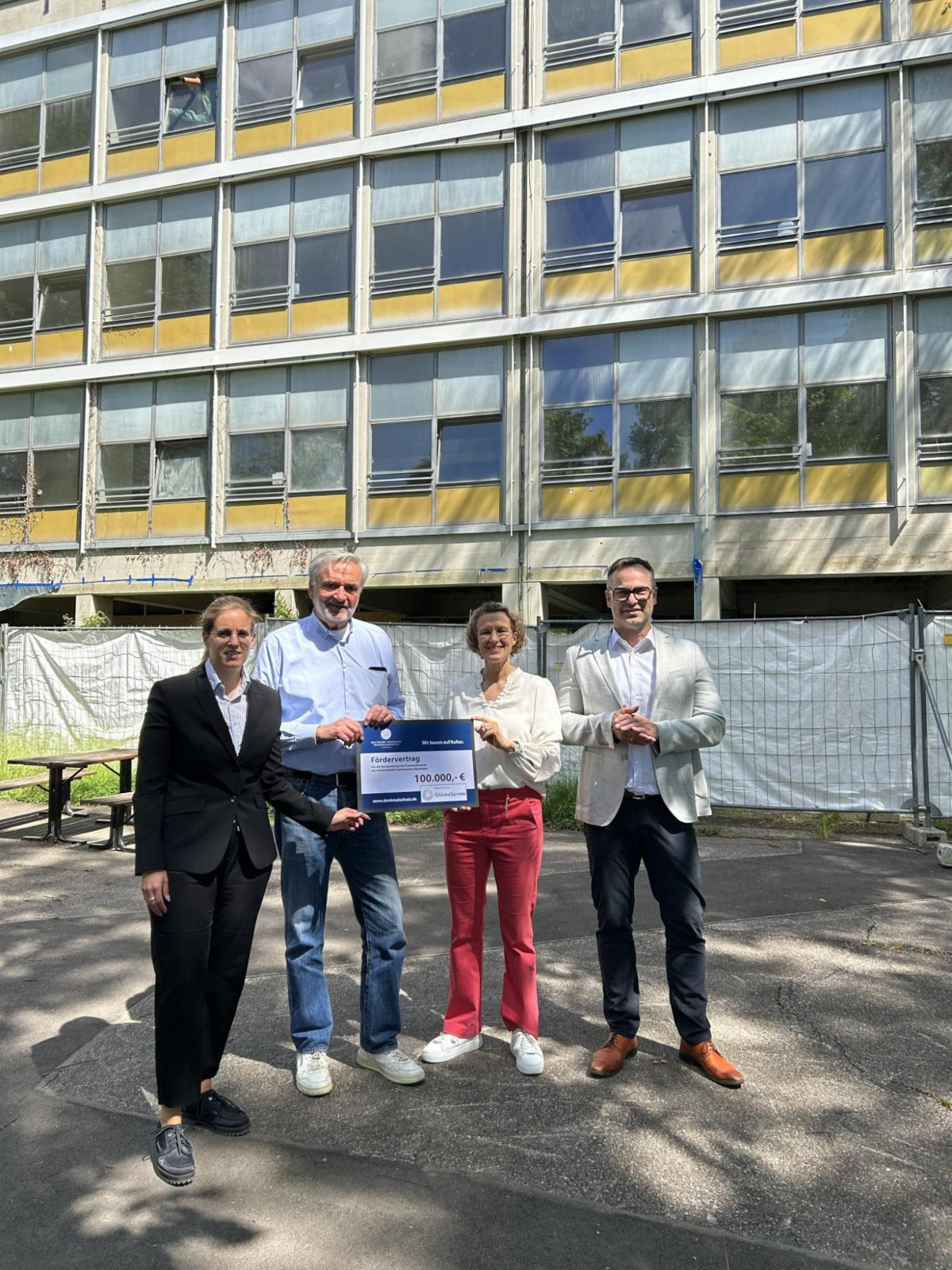 Viktoria Kesper, Pressesprecherin von Lotto BW, und Dr. Fritz Fischer, Ortskurator der Deutschen Stiftung Denkmalschutz, übergeben den symbolischen Fördervertrag an Baubürgermeisterin Eva Noller und Schulleiter John Ahlskog (von links).
