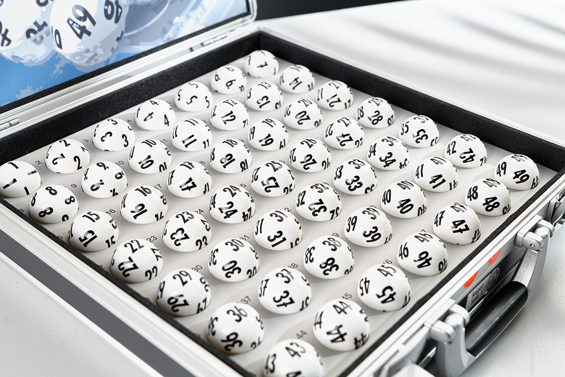 49 Lottokugeln in grauem Koffer.