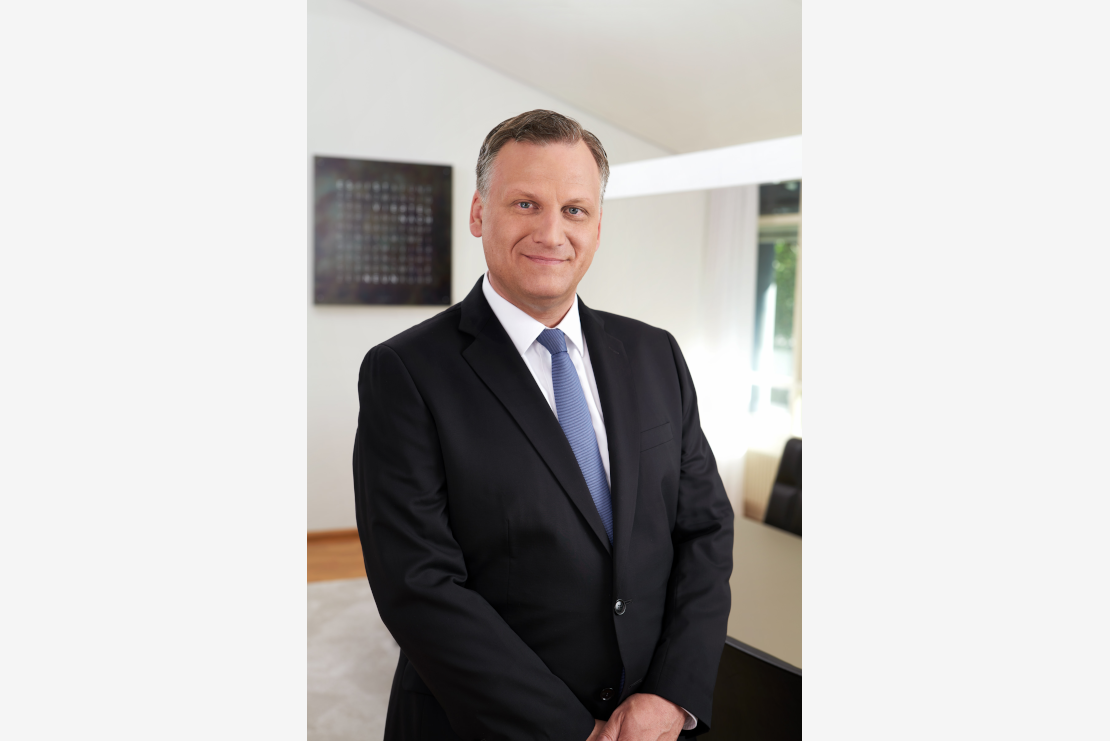 Michael Grepl, Geschäftsführer von Lotto BW, trägt Anzug und lächelt in die Kamera.