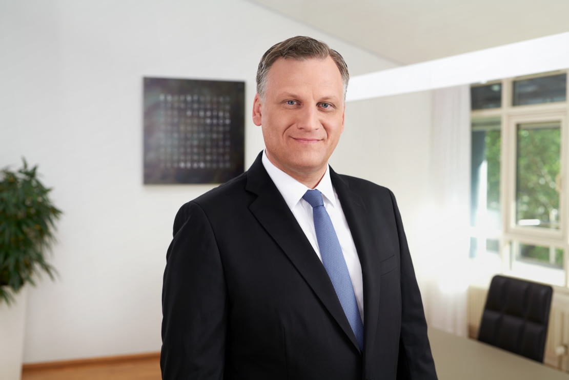 Michael Grepl, Geschäftsführer von Lotto BW, trägt Anzug und lächelt in die Kamera.