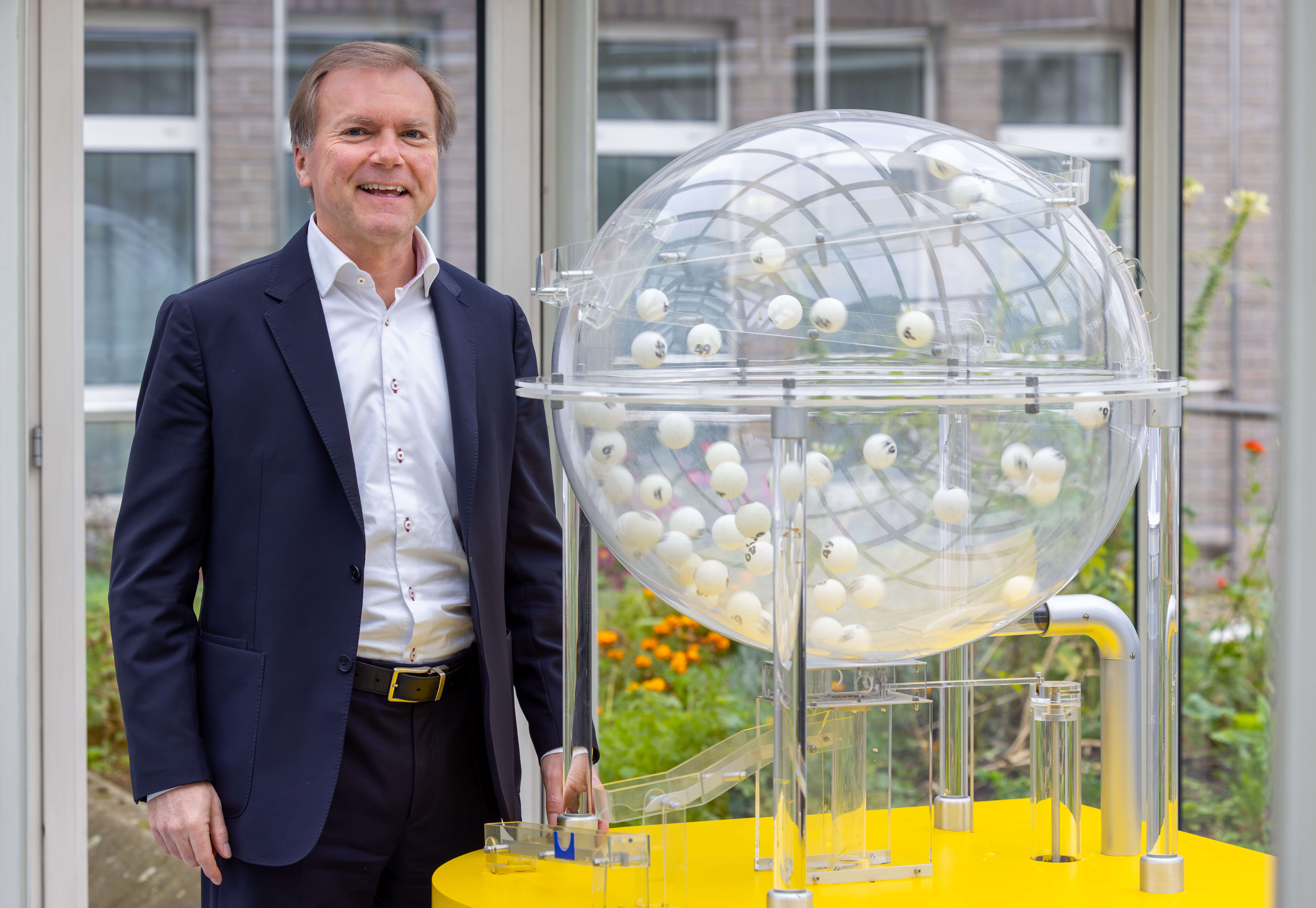Paul Nemeth neben Ziehungsger&auml;t mit Lotto-Kugeln.