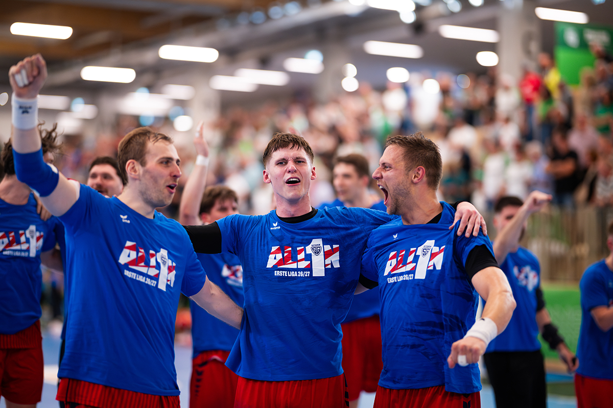 Jubelnde Handballmannschaft feiert Aufstieg