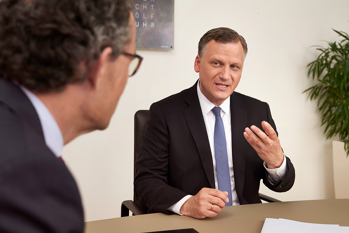 Michael Grepl, Direktor, sitzt am Tisch und spricht mit Georg Wacker, Geschäftsführer von Lotto BW.